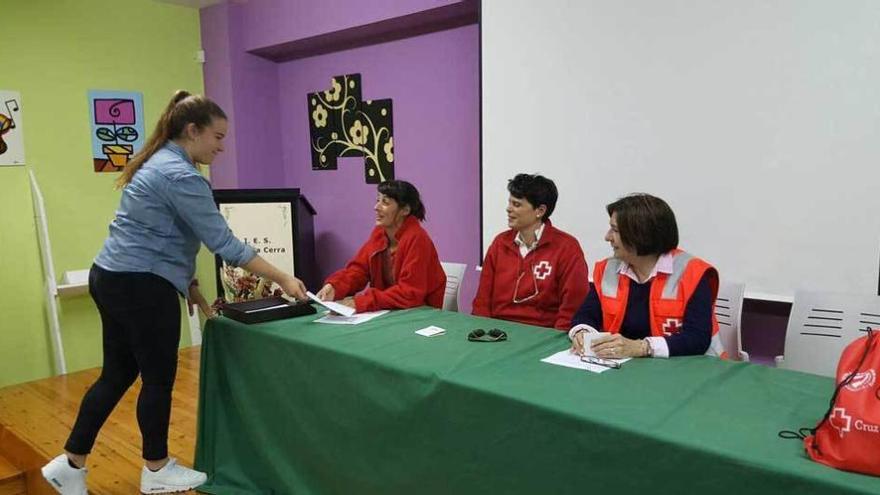 Una estudiante entrega a los voluntarios el dinero recaudado.