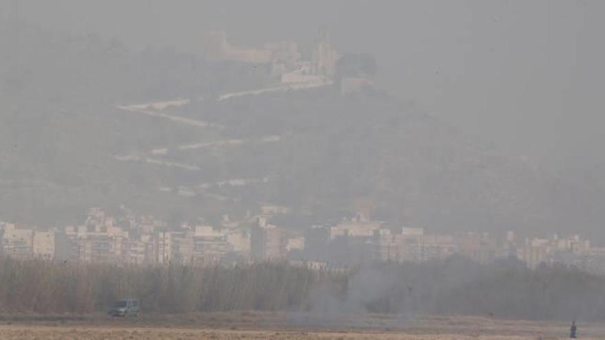 El humo de la quema de la paja de arroz impedía ayer ver la ciudad de Cullera, con el castillo al fondo, a menos de tres kilometros.