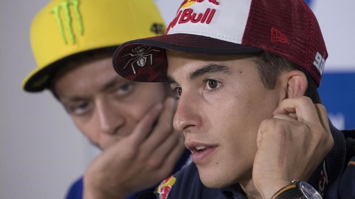 Valentino Rossi escucha atentamente las explicaciones de Marc Márquez, en una conferencia de prensa del 2016.