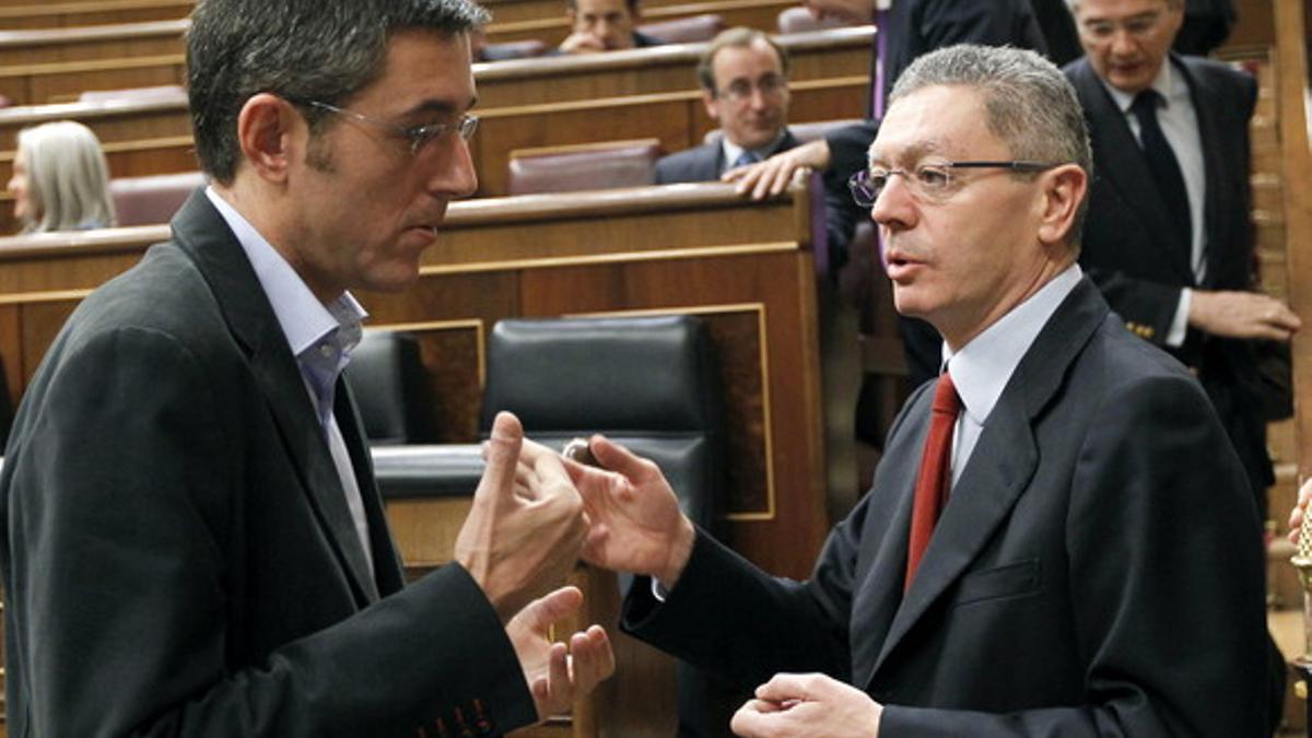 El ministro de Justicia, Alberto Ruiz Gallardón (derecha), conversa con el secretario general del grupo parlamentario socialista, Eduardo Madina, hoy en el Congreso.