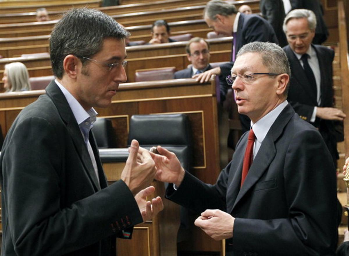 El ministro de Justicia, Alberto Ruiz Gallardón (derecha), conversa con el secretario general del grupo parlamentario socialista, Eduardo Madina, hoy en el Congreso.