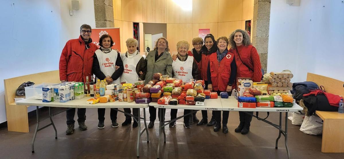 Integrantes de Cruz Roja y Cáritas de Sada posan con las donaciones de los sadenses.
