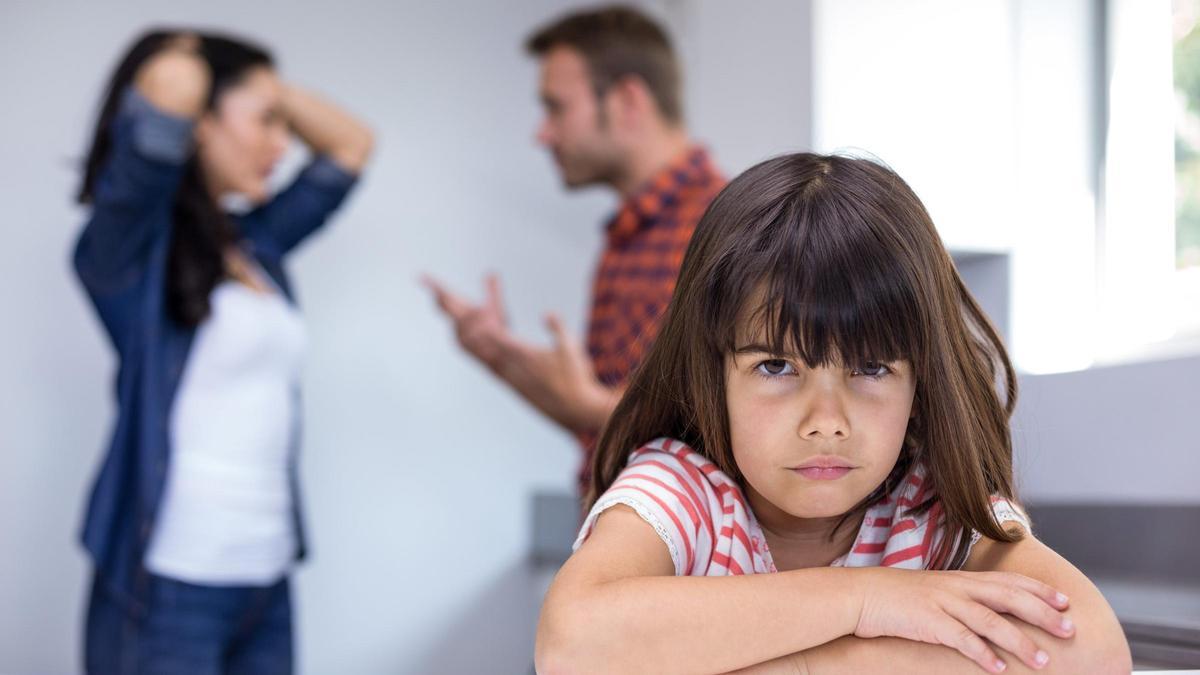 Una niña frente a sus padres, tras una discusión.