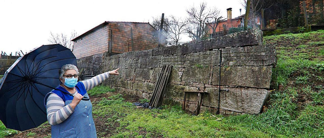 Rosa Pereira muestra el muro que tendría que saltar para entrar en casa. |   // ANXO GUTIÉRREZ