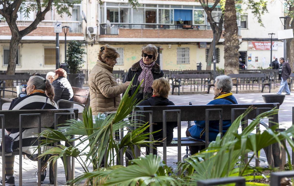 Un grupo de pensionistas charla en un parque.