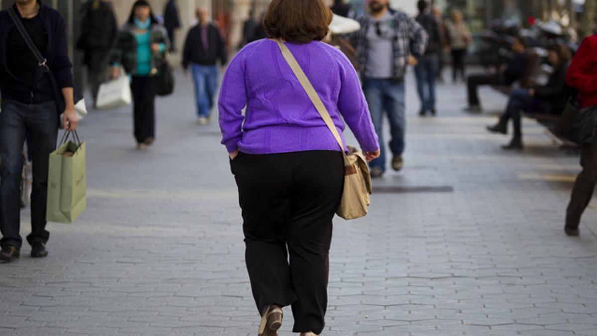 Una mujer con sobrepeso pasea por Barcelona.