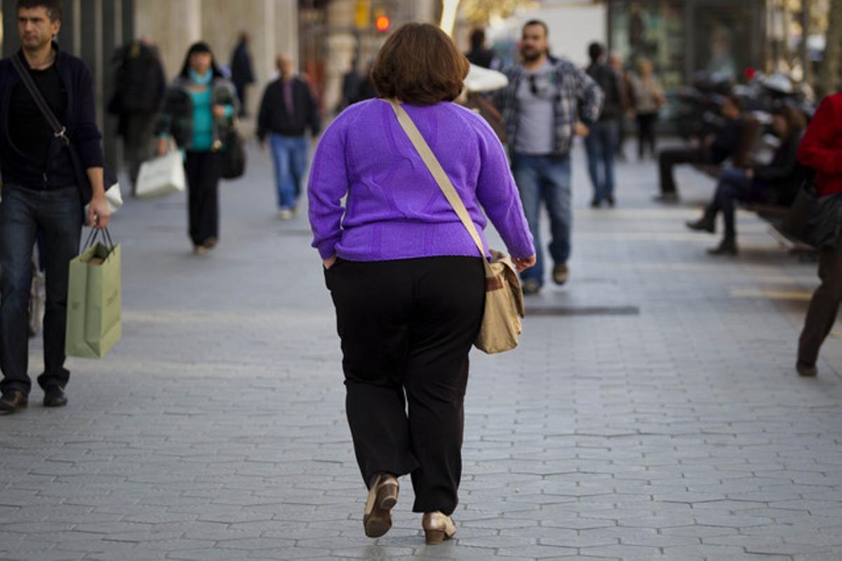 Una dona amb sobrepès passeja per Barcelona.