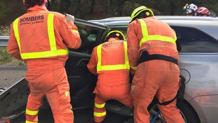 Los bomberos liberan al conductor del vehículo atrapado.