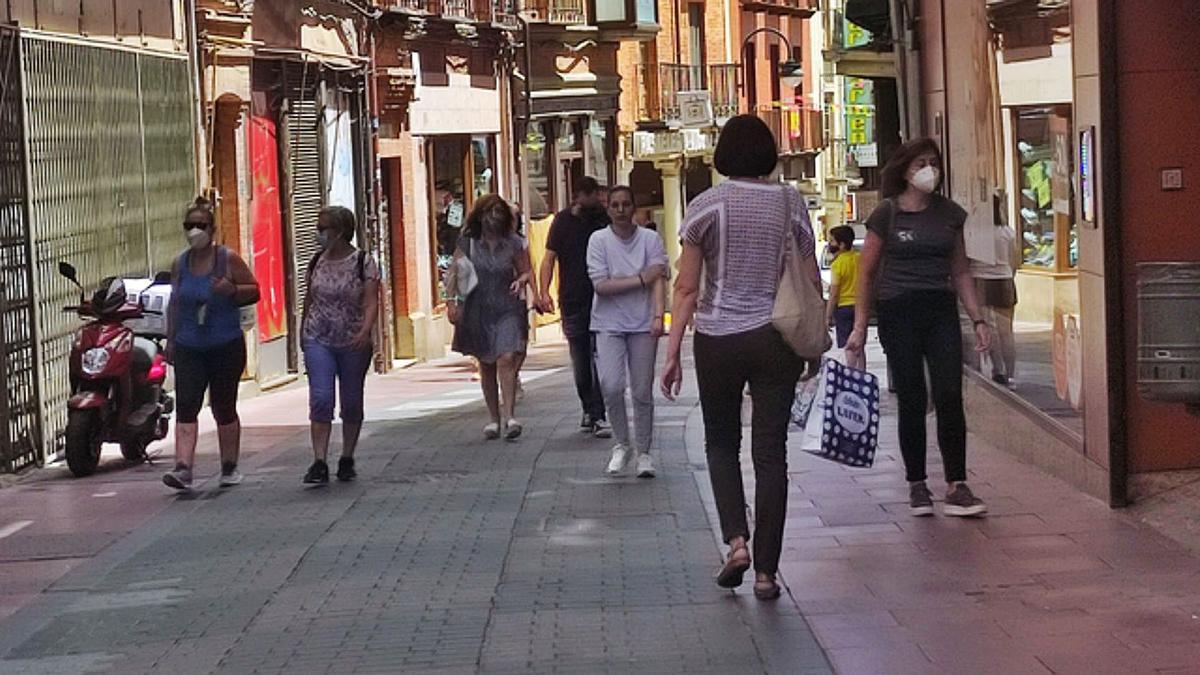 Centro de Negocios, donde ayer se va vacunó a varias quintas con Janssen y  a la izquierda, una familia por la calle La Rúa de Benavente, sin la mascarilla y arriba en personas con y sin mascarilla por La Rúa. | |  E. P.