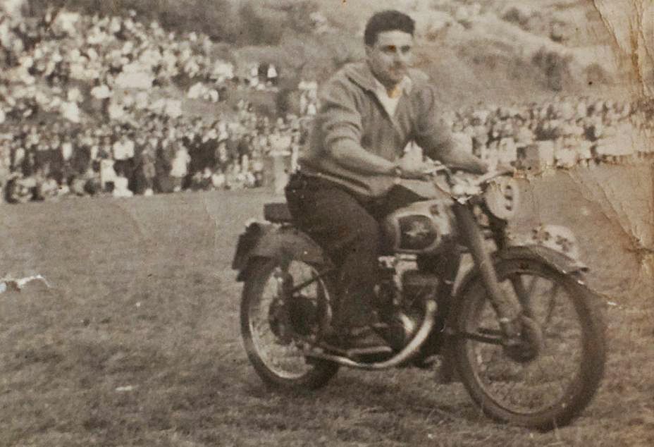 Silvino López montado en una moto por un prado. / R. S.