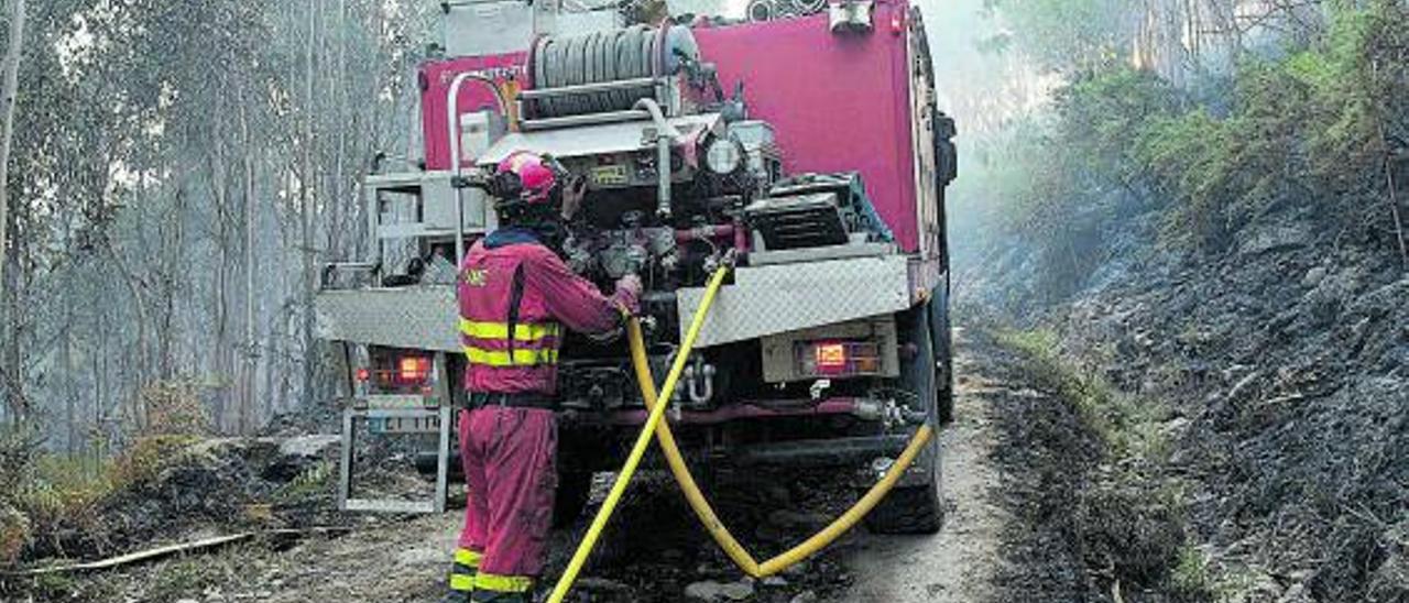 Un miembro de la UME trabaja, ayer, en la extinción del fuego que se originó en Boiro. |   // CÉSAR ARXINA/E. PRESS