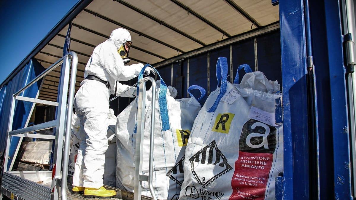 Operarios retiran restos de amianto con los trajes de protección.