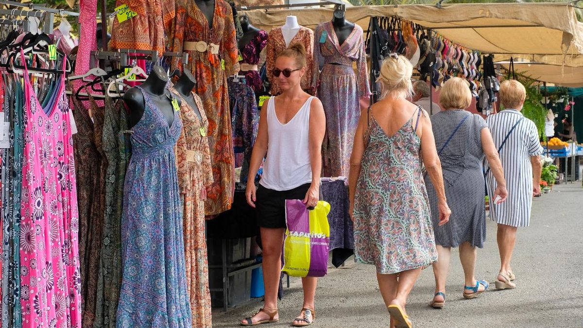 Turistas pasean y observan los puestos del mercadillo de la localidad grancanaria de Arguineguín.