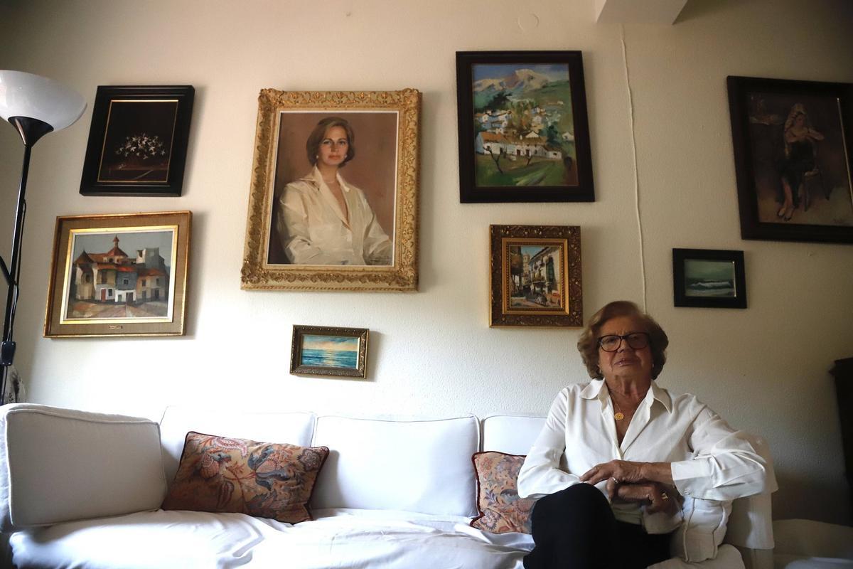Georgina Küstner, junto a su retrato en un rincón de su casa en Málaga, este mes.