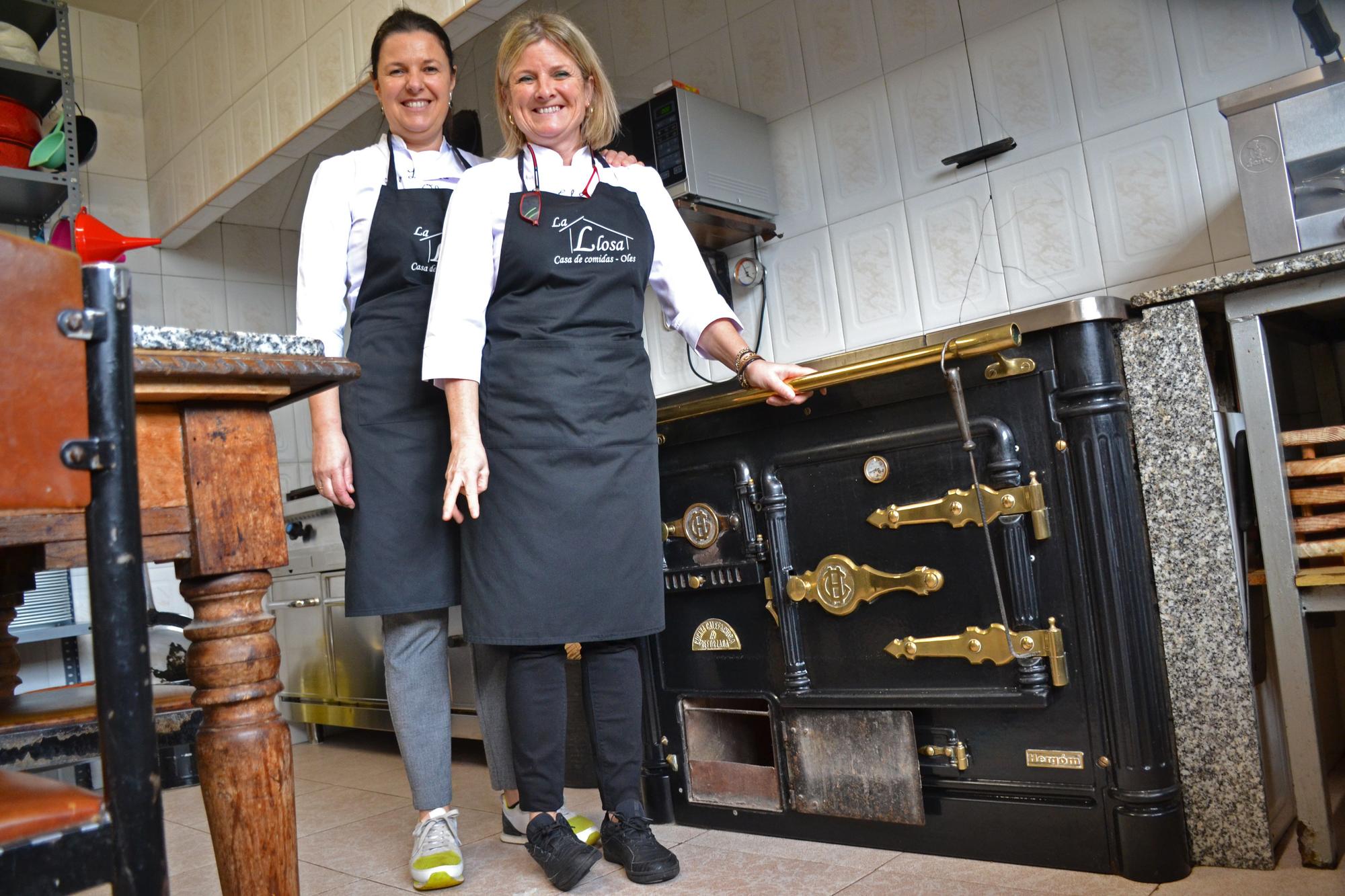 Luisi y Teresi García Noval, ante la cocina de carbón y leña que tienen en su establecimiento.