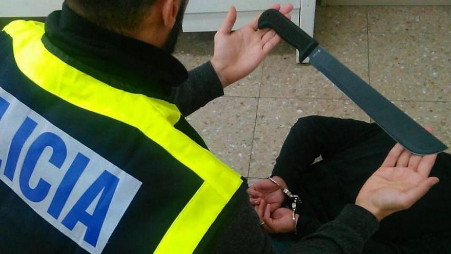 Un agente de la Guardia Civil muestra un gran machete intervenido a la banda.