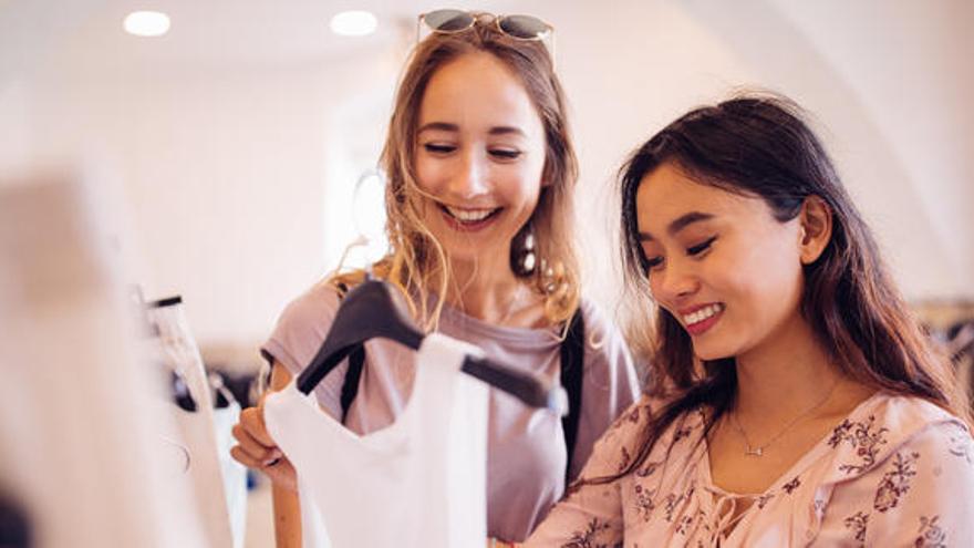 Dos mujeres realizan compras en un comercio.