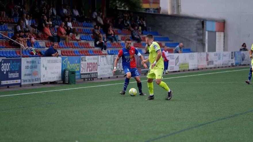 Cristian controla el balón ante un rival en el partido que enfrentó al Langreo con el Getafe B.