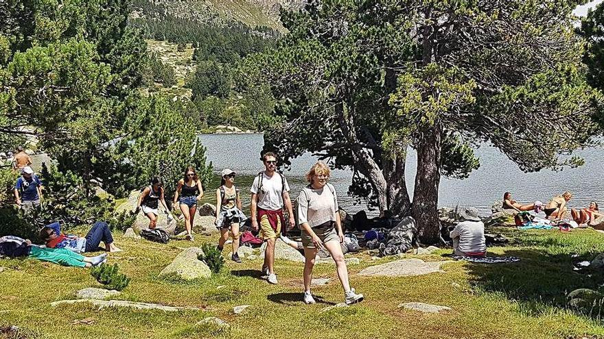 Persones caminant i d&#039;altres prenent el sol, a tocar del llac de Malniu, la segona setmana d&#039;agost |