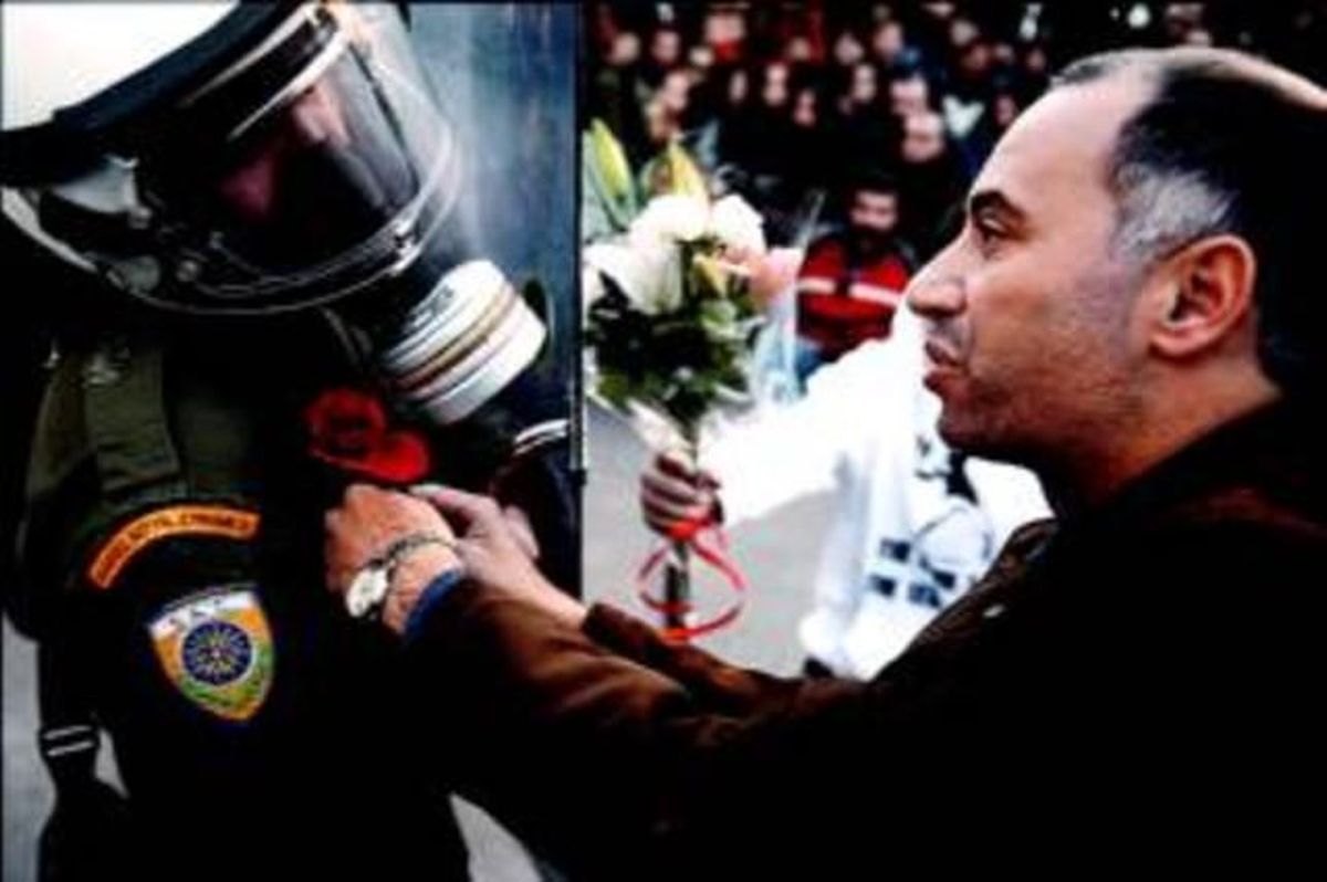 Un manifestant col.loca una rosa a l’uniforme d’un policia antiavalots durant una protesta davant del Parlament, ahir a Atenes.