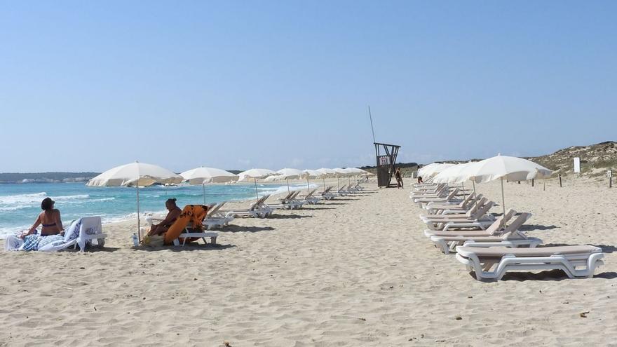 Imagen de archivo de una playa de Formentera con sombrillas y hamacas. | C.C.