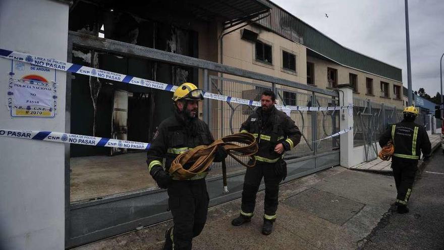 Los bomberos ayer ante la nave del polígono de Trabanca Badiña que se incendió al mediodía del sábado. // Iñaki Abella