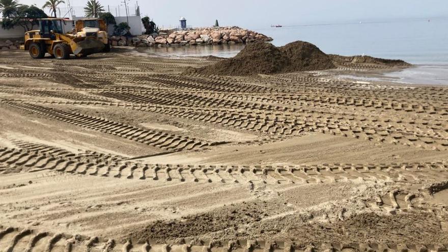 Operarios mueven arena en la playa de La Fontanilla.