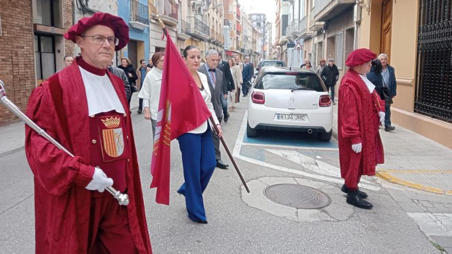 La alcaldesa de Carcaixent porta la bandera en el desfile oficial hacia el auditorio.