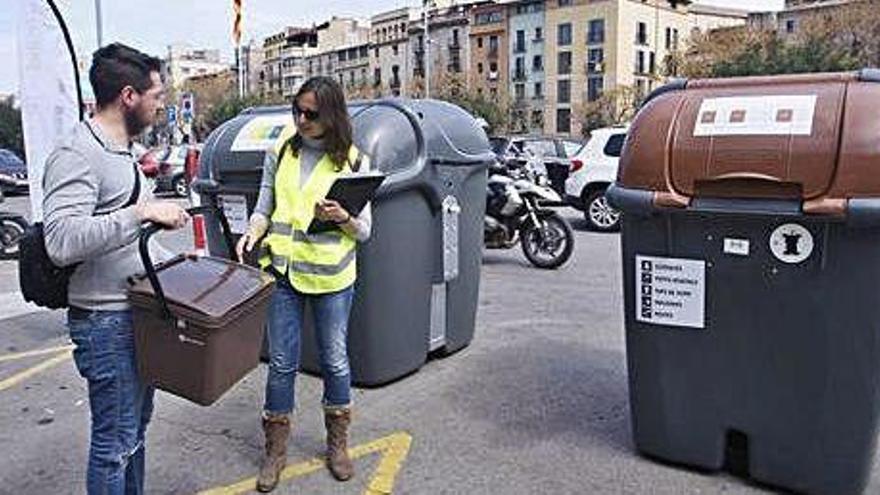 Una tècnica ensenyant com funcionen els contenidors de plaça Catalunya.