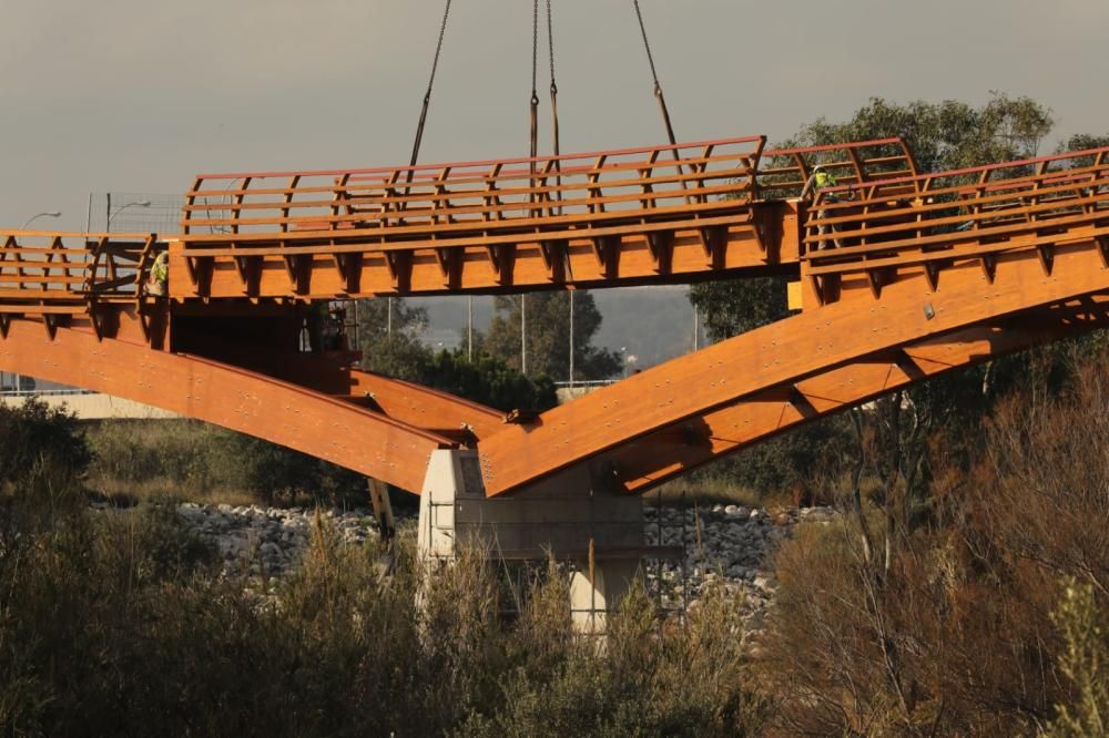 La instalación del último tramo del puente de madera sobre el río Guadalhorce ha comenzado este martes.