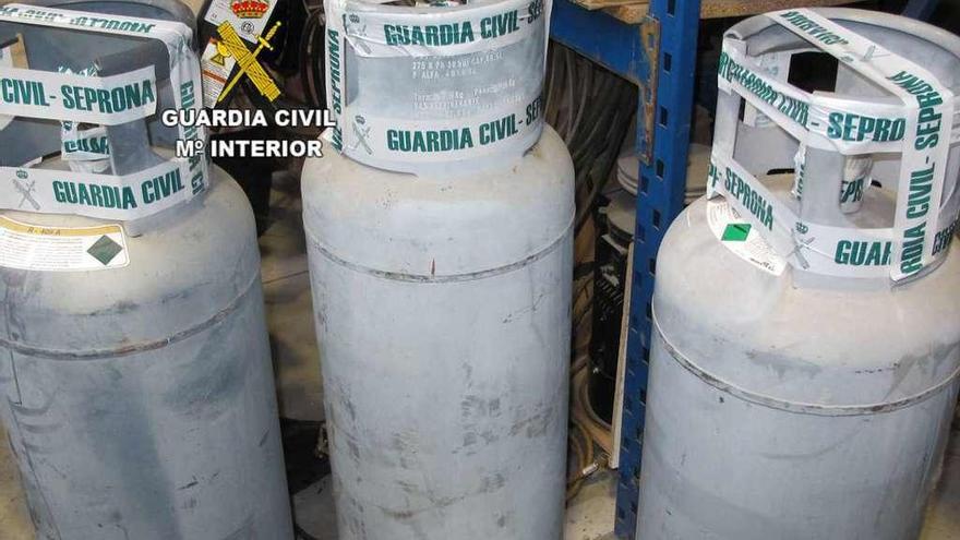 Las tres botellas con gases HCFC ilegales requisadas por el Seprona en la nave de la empresa investigada.