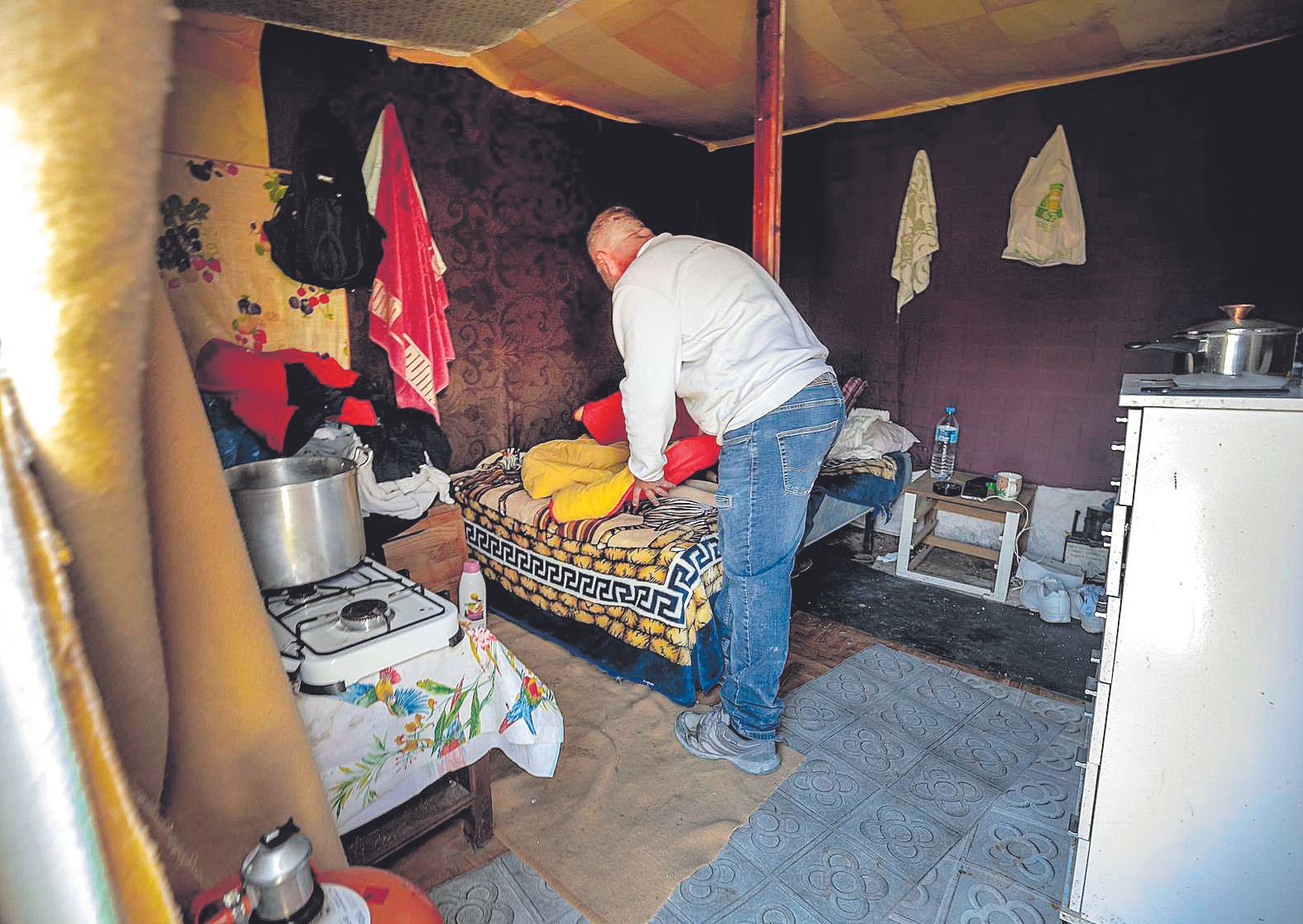 Interior de la barraca de Renato, con su cama y una pequeña cocina de butano.