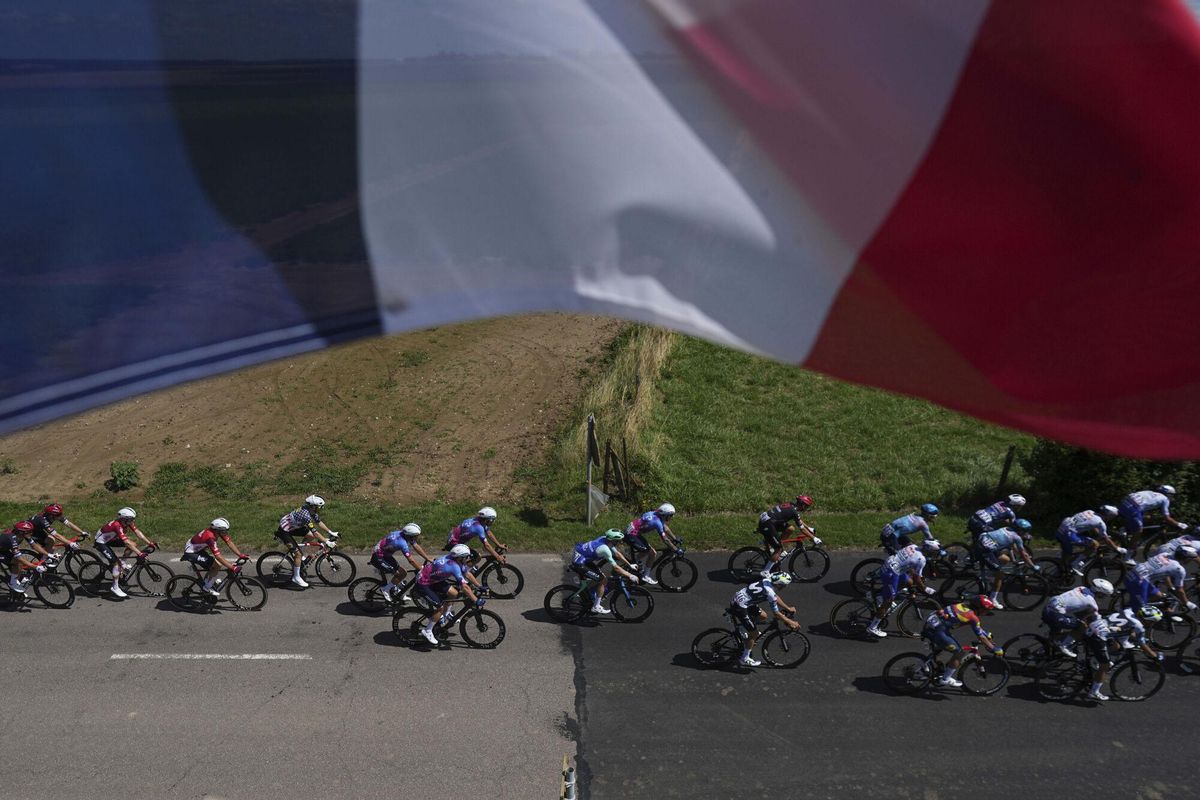 The pack rides under a French flag during the fourth stage of the Tour de France cycling race over 172.2 kilometers (107 miles) with start in Amiens and finish in Rouen, France, Tuesday, July 8, 2025. (AP Photo/Thibault Camus) Associated Press / LaPresse Only italy and spain. EDITORIAL USE ONLY/ONLY ITALY AND SPAIN