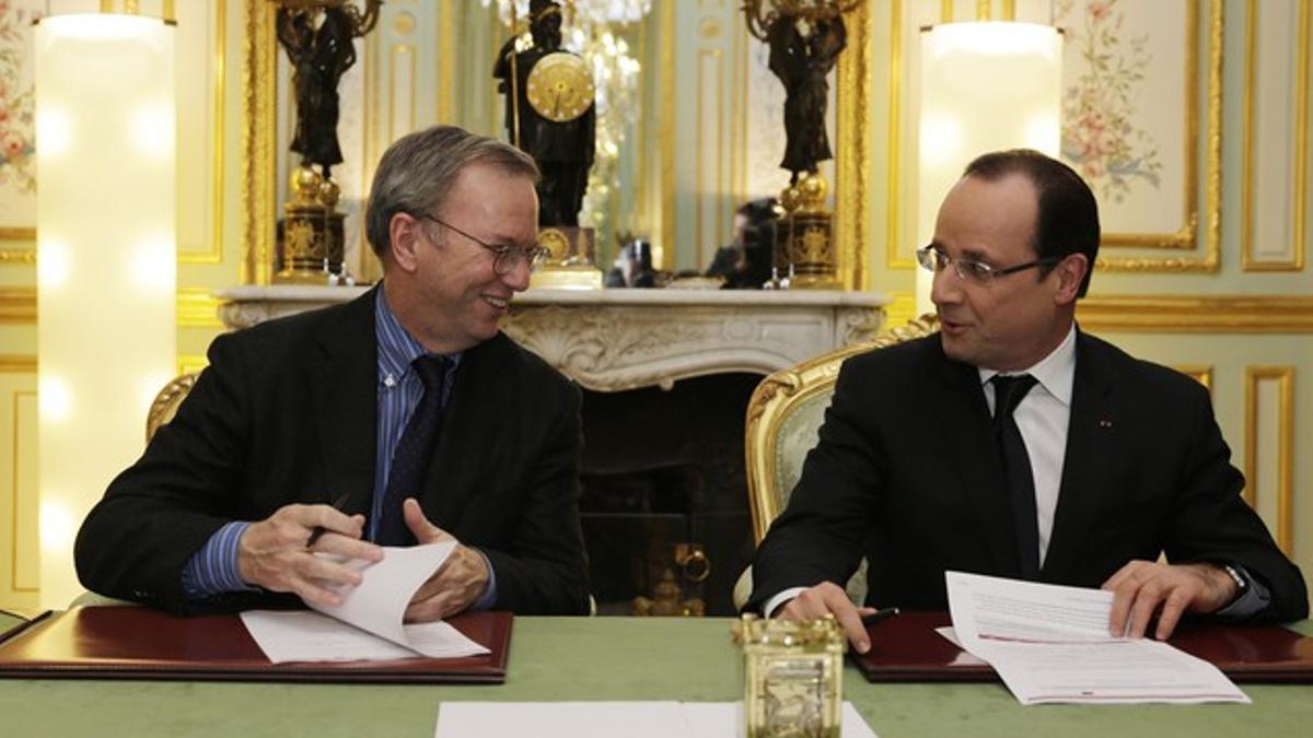 Schmidt (izquierda) y Hollande firman el acuerdo, en París.