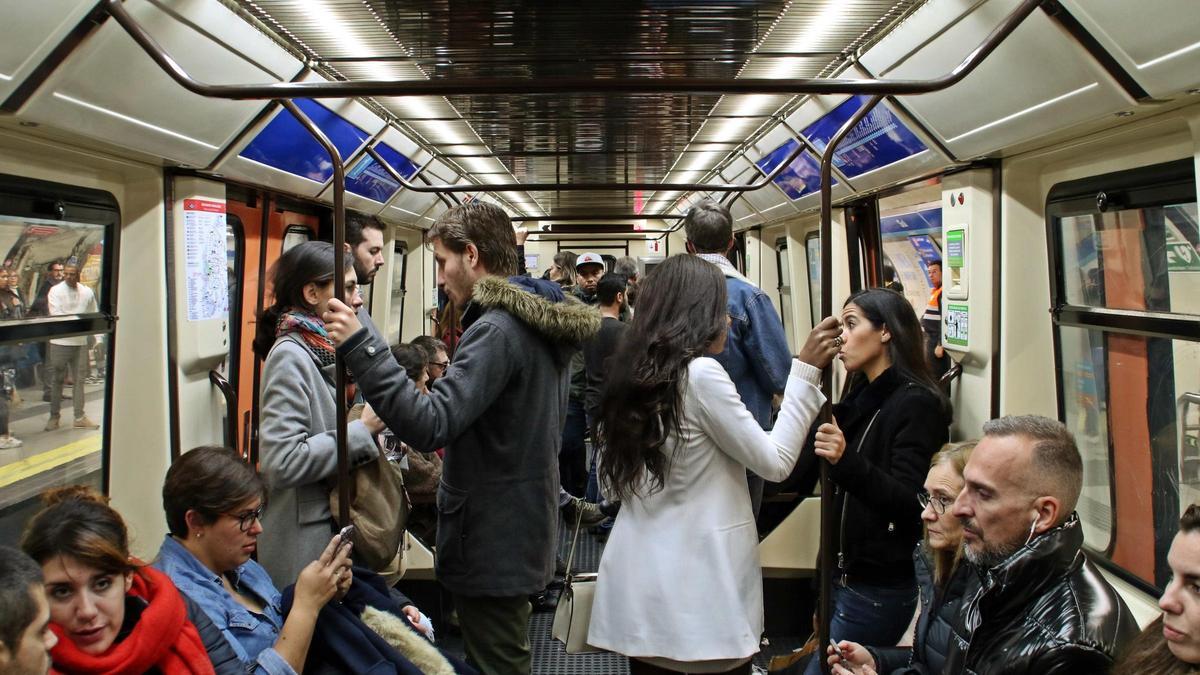 Varias personas viajan a bordo de un vagón del metro en Madrid.