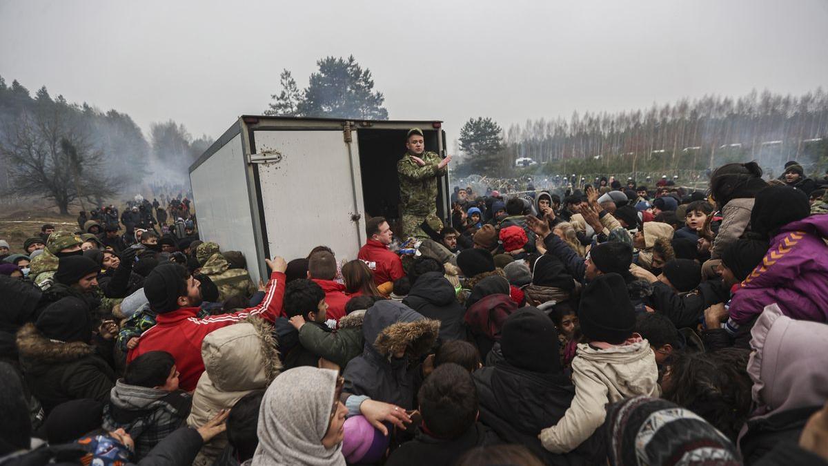 Refugiados se concentran junto a un camión con ayuda humanitaria en la región de Grodno, en la frontera entre Bielorrusia y Polonia.