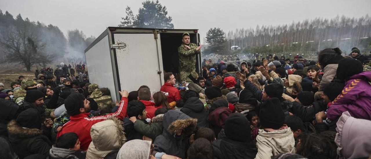 Refugiados se concentran junto a un camión con ayuda humanitaria en la región de Grodno, en la frontera entre Bielorrusia y Polonia.