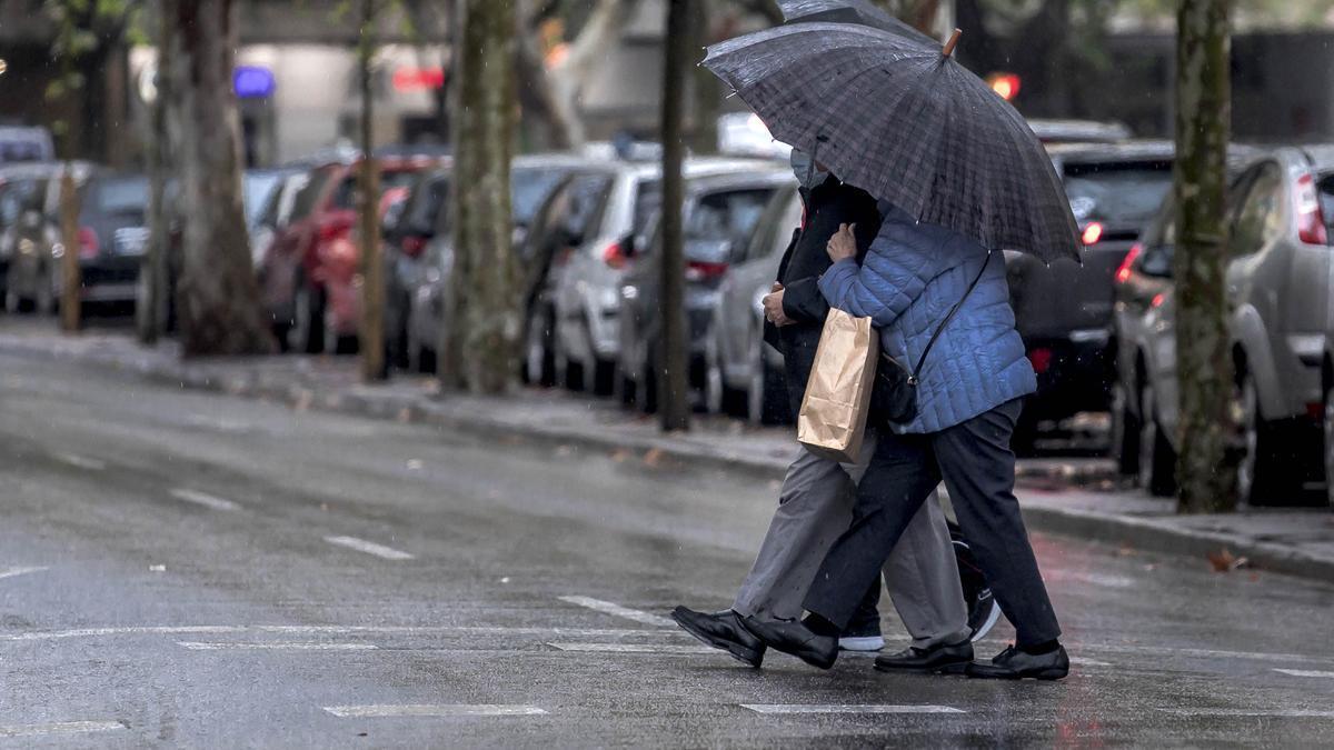 Imagen de archivo de personas protegiéndose de la lluvia