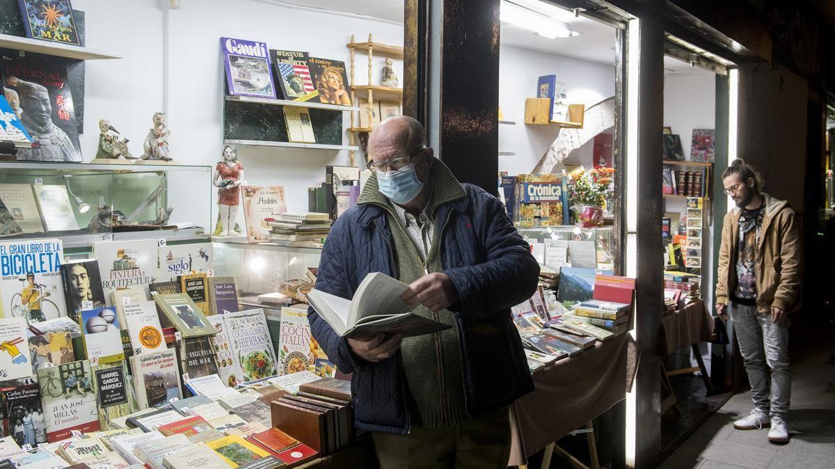 Mario Pérez, hojeando un libro en su recién inaugurada librería de segunda mano, Set Vides, en el Raval.