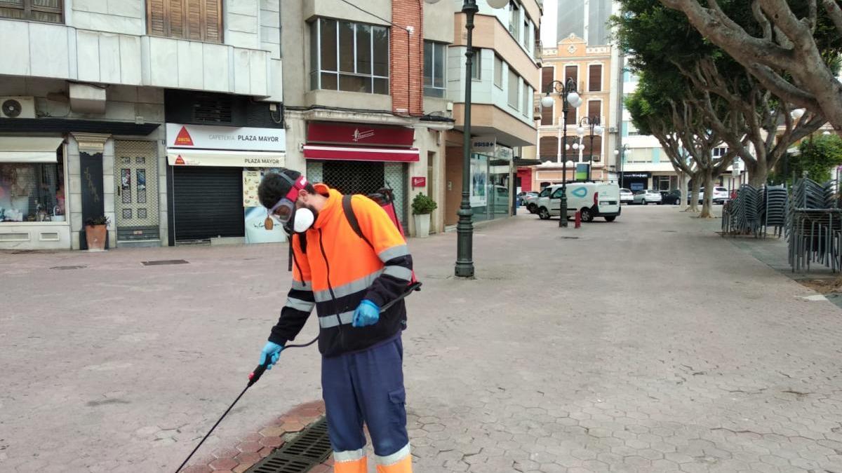 Limpieza de un imbornal de la Plaça Major.