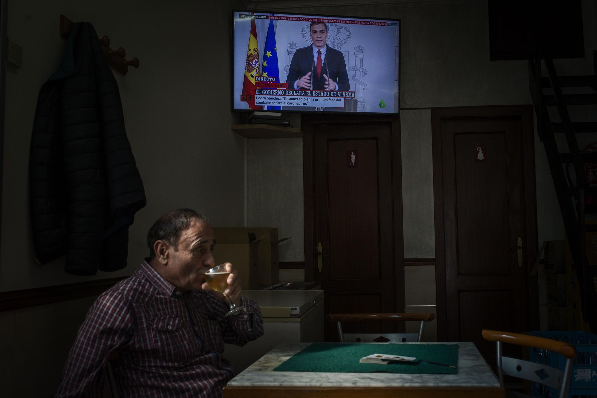 Un hombre consumiendo una cerveza mientras Pedro Sánchez anunciaba la declaración del estado de alarma, en marzo de 2020. // BRAIS LORENZO