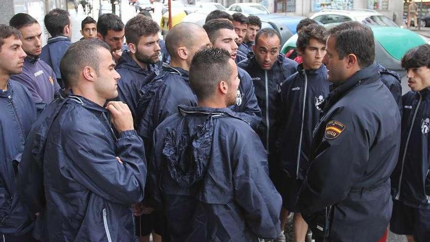 Los jugadores dialogan con un policía tras visitar el negocio del presidente el 24 de abril.