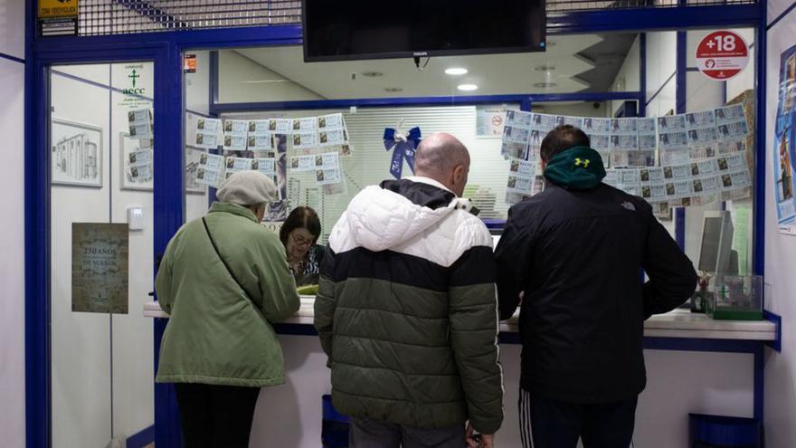 Tres personas en una administración de lotería, ayer.