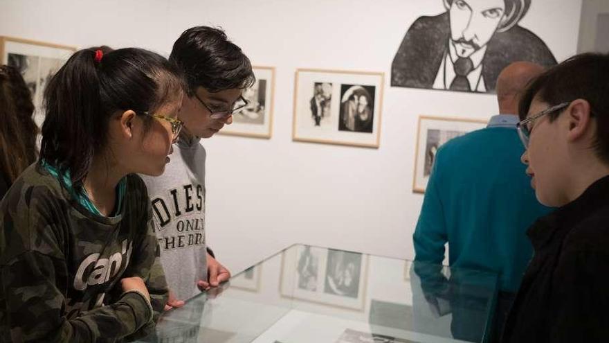 A la izquierda, varios jóvenes observan las ilustraciones de Marta Gómez-Pintado y a la derecha, la autora durante la visita guiada de apertura.