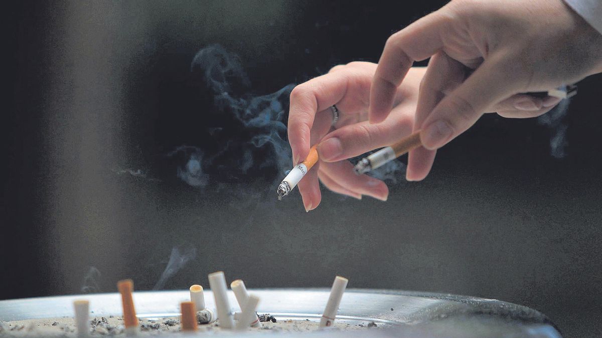 Dos personas apagan las colillas de los cigarros.