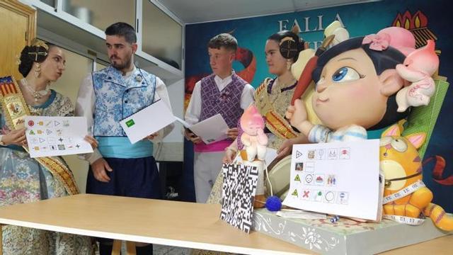 Las falleras mayores y presidentes, junto a un ninot con los pictogramas y la explicación en Braille, en el casal de la comisión. | T.Á.C.