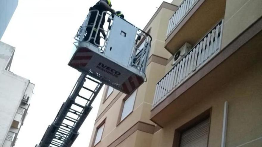 Los bomberos, saneando la fachada donde se ha producido el desprendimiento