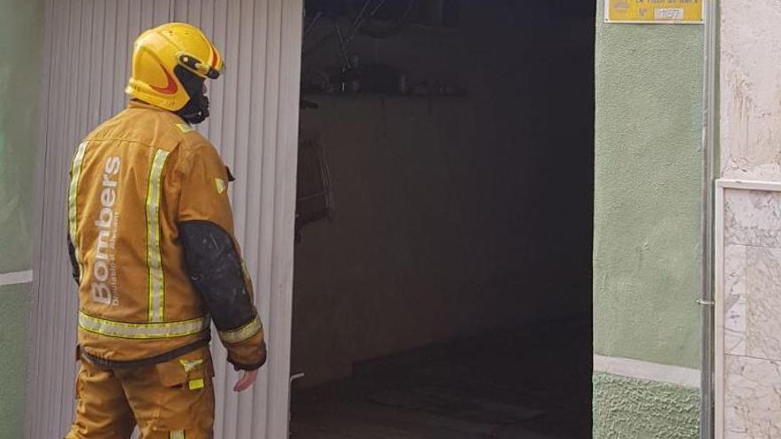 Un bombero accediendo al almacén incendiado