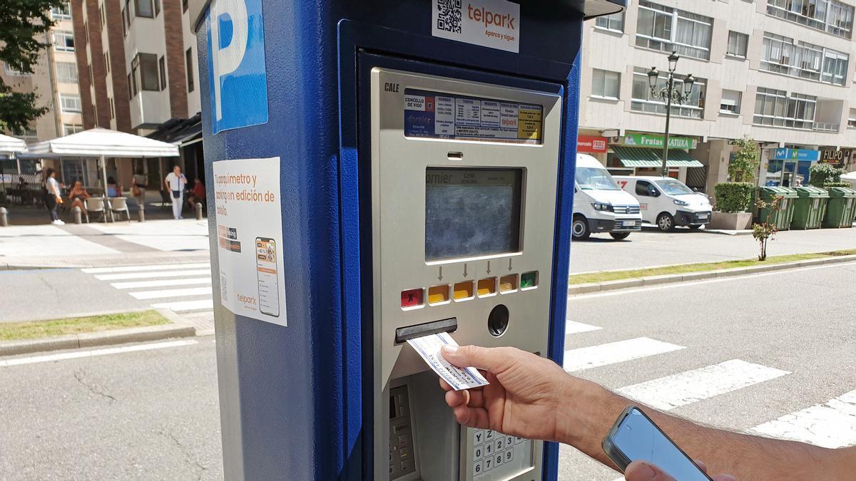 Un usuario de la zona azul de Vigo, en un parquímetro.