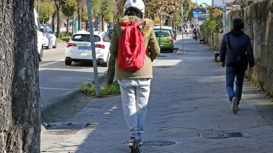 Un usuario de patinete eléctrico circulando por la acera en la Gran Vía de Vigo. // Marta G. Brea